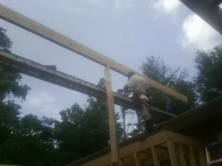 Carpenter setting a ridge beam over a new addition frame — Ice Dam Removal by Roofing Brothers in Union Bridge