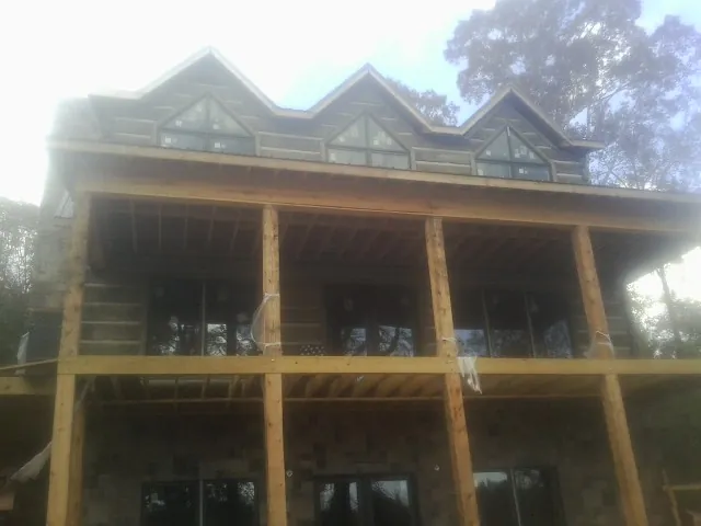 Dormers and porch framing on a large log home under construction — Roof Coating work by our crew in Union Bridge