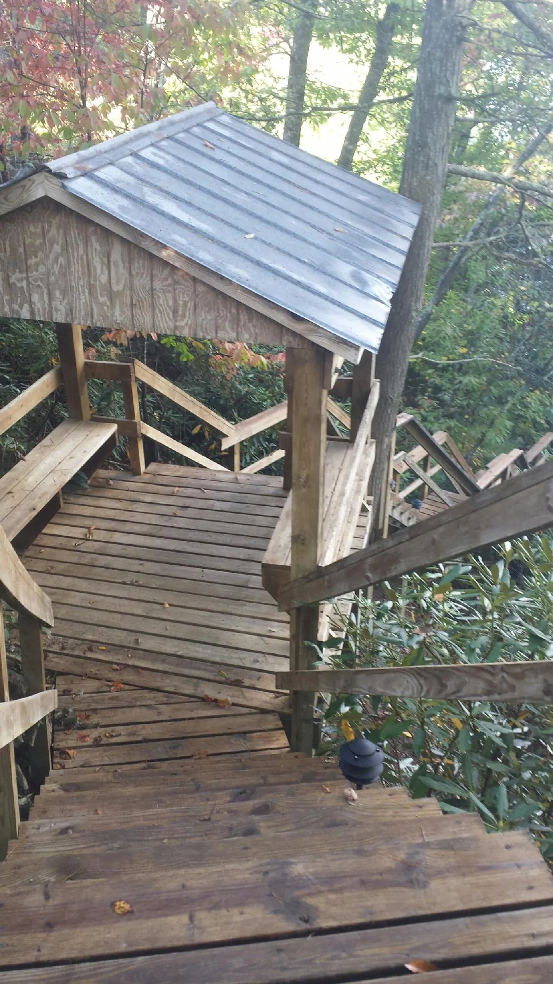 Metal roofed shelter over wooden steps on a wooded walkway — Skylight Repair & Installation work by our crew in Union Bridge